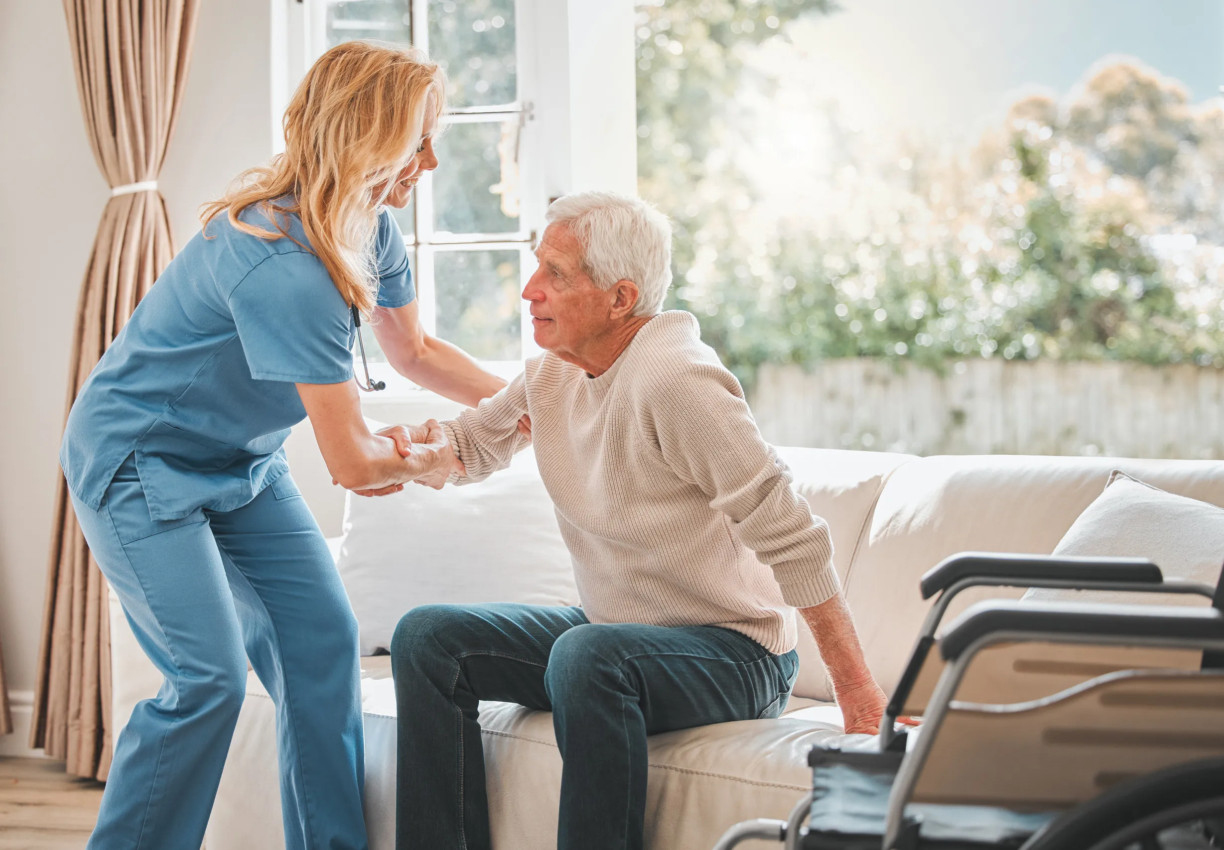 a young nurse helping her elderly male patient stand up a young nurse helping her elderly male patient stand up